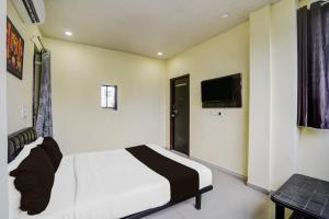 a bedroom with a bed and a tv on the wall at HOTEL O REGAL INN in Dhantoli