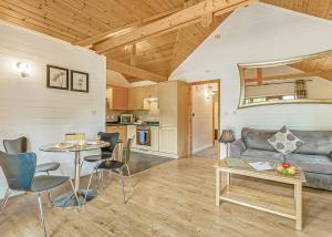 a living room with a couch and a table at Tilford Woods Lodge Retreat in Farnham