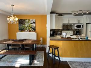 a kitchen with a table and a dining room at Serene Getaway Nordic Spa , Sauna, Nature & Pool in Rawdon