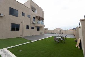 a patio with chairs and a lawn in front of a building at The Riverdale, Kumasi in Kumasi