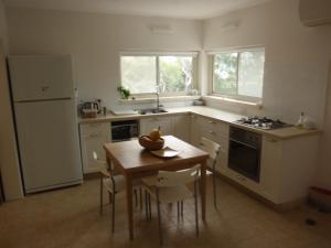 una cocina con una mesa con un bol de fruta. en Lovely home above the Kinneret, en Karkom