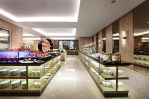 a restaurant with a buffet of food on display at Harper Perintis by ASTON in Makassar