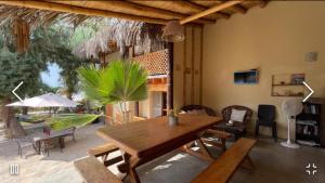 a dining room with a wooden table and chairs at Muelle Viejo Bungalows in Los Órganos