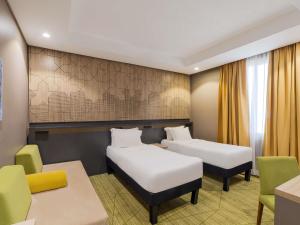 a room with two beds and a table and chairs at ibis Styles Makkah in Mecca +115 photos