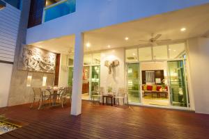 a house with a deck with a table and chairs at Villa Paradiso in Bang Tao Beach