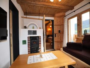 a living room with a fireplace in a tiny house at Rustic cabin with sauna near the ski area in Pankrazberg