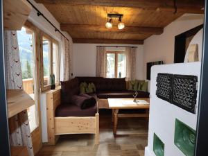 a living room with a couch and a table at Rustic cabin with sauna near the ski area in Pankrazberg +10 photos