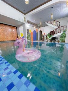 une piscine avec une licorne rose dans l'eau dans l'établissement Vạc Villa - Thị Trấn Tam Đảo, à Yen