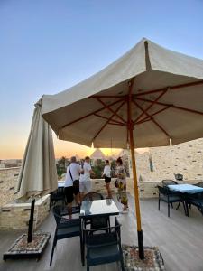 a group of people standing under a large umbrella at Pyramids Night Hotel &Free pickup shuttle in Giza