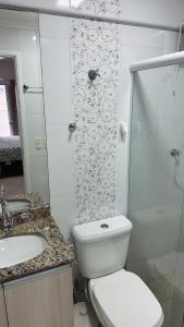 a bathroom with a toilet and a sink and a shower at Espaço da Char in Praia Grande