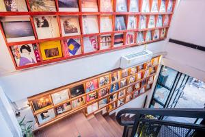 a room with a wall of pictures on the wall at Bed & Beach Hostel Karon in Ban Karon