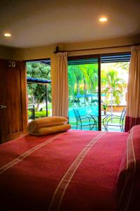 San Juan Bautista TuxtepecにあるHotel Campestre Santa Claraの大きなベッドと大きな窓のある寝室