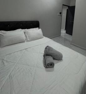 a white bed with a pair of shoes on it at D'La Villa Homestay in Jertih +5 photos