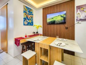 a dining room with a table and a tv on a wall at Serene City Abode in Santa Rosa