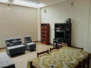a living room with a table and chairs and a television at House explorer in Cusco