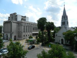 a large white building with a church at Cora Centru Pitesti in Piteşti