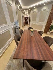 a conference room with a wooden table and chairs at Luxury diamond apartment in wesal residences compound in New cairo