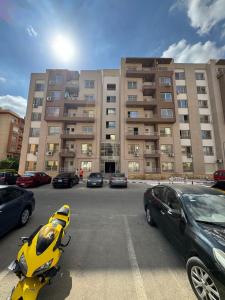 a parking lot with cars parked in front of a building at Luxury diamond apartment in wesal residences compound in New cairo