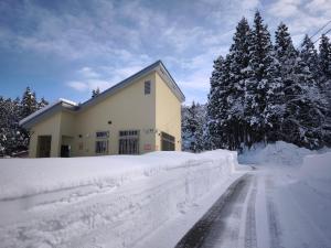 una casa está cubierta de nieve junto a una carretera en BBQ 夏季プール マッサージチェア 舞子スノーリゾート 加賀屋旅館 南魚沼 Kagaya Ryokan 加贺屋旅馆, en Minami Uonuma