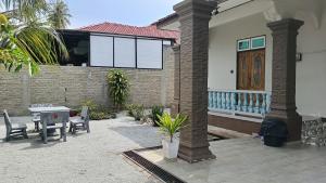 Un patio con una mesa y sillas frente a una casa. en Homestay Annur Barakah, en Kampung Raja