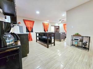 a room with a kitchen and a living room at 3Bd House 8 min to Int'l Airport with WiFi, Gated Parking and Hot Wtr in Ladyville +4 photos