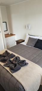 a bedroom with a bed with towels on it at Anchorage Motel in Whitianga