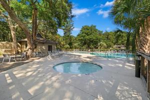 a swimming pool with chairs and a tree at IC50: 50 Inlet Cove in Kiawah Island