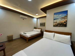 a bedroom with two beds and a couch at Mom Shie's Apartelle in Las-ud +66 photos