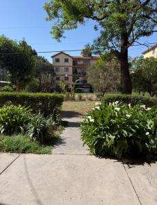 a garden with flowers and a building in the background at Departamento en Salta Capital in Salta