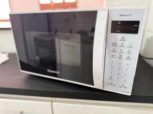ベレンにあるCasa rosa - conforto com split, wifi e água quenteのカウンターの上に置かれた電子レンジ +14枚の写真