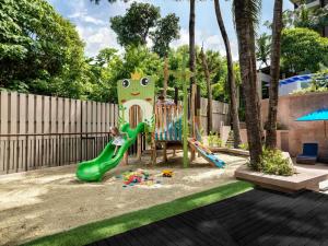 a child playing on a playground in a backyard at Novotel Phuket Kata Avista Resort and Spa in Kata Beach +236 photos