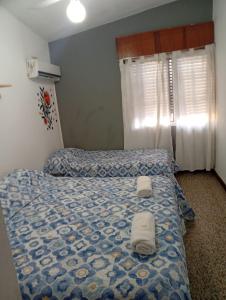a bedroom with a bed with two towels on it at Hotel inti huasi in Villa Carlos Paz