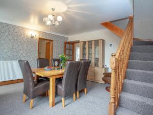 a dining room with a table and chairs and stairs at Tanglewood in Bugle