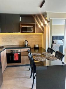 a kitchen with a table and chairs and a bed at Central depto 2 dormitorios en distrito Icono in Los Ángeles