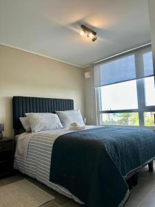 a bedroom with a large bed and a large window at Central depto 2 dormitorios en distrito Icono in Los Ángeles