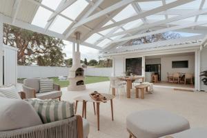 an outdoor patio with a white conservatory with a fireplace at White Haven Port Willunga 6 Bedroom group entertainer with Games shed and Pizza oven in Port Willunga