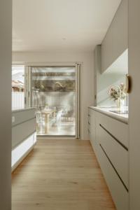 a kitchen with white cabinets and a wooden floor at White Haven Port Willunga 6 Bedroom group entertainer with Games shed and Pizza oven in Port Willunga +64 photos
