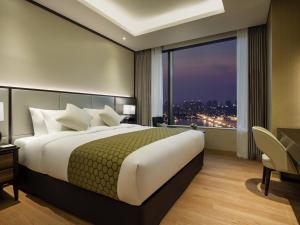 a bedroom with a large bed and a large window at Grand Mercure Ambassador Hotel and Residences Seoul Yongsan in Seoul
