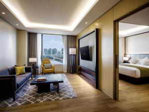 a hotel room with a bed and a living room at Grand Mercure Ambassador Hotel and Residences Seoul Yongsan in Seoul