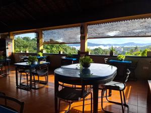 a restaurant with tables and chairs and large windows at Blue Pillars Kandy in Kandy