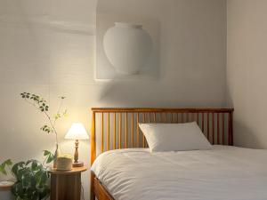 a bedroom with a bed and a vase on the wall at Oknuri in Seoul