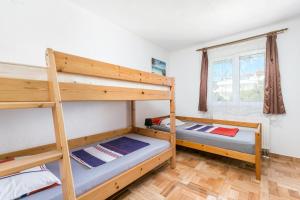 two bunk beds in a room with a window at Apartments with parking space Kastel Stafilic, Kastela - 24155 in Kaštela