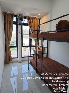 a room with two bunk beds and a window at Neomi Homestay Malang in Wendit