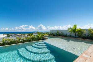 ein Swimmingpool mit Blick auf das Meer in der Unterkunft Paravian by Casago in Playa del Carmen