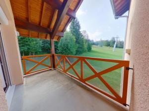 an open door to a balcony with a view of a field at Appartement confortable au pied des pistes - 6 pers - FR-1-834-14 in Prémanon
