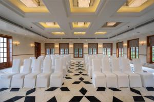 a row of white chairs in a room with a checkered floor at Radisson Resort Mount Abu in Mount Ābu