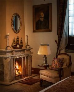 a living room with a fireplace and a portrait of a man at Hacienda El Carmen Hotel & Spa in Portes Gil