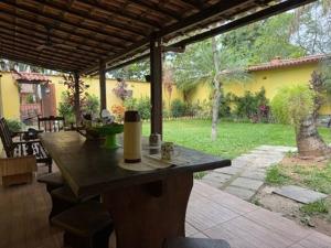 a patio with a table with a view of a yard at Casa com piscina e churrasqueira para familia in Maricá +8 photos
