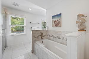 a white bathroom with a tub and a window at AV3-20: 3 20th Avenue in Isle of Palms +52 photos