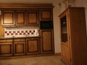 a kitchen with wooden cabinets and a counter top at Appartement 4 pièces 8 pers rénové avec parking aux Carroz d'Arâches - FR-1-572-335 in Arâches-la-Frasse